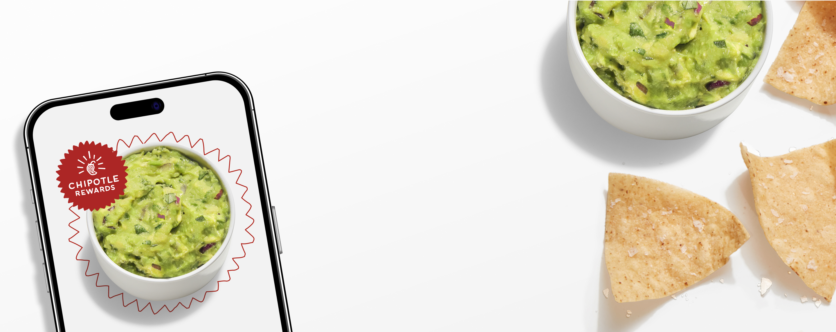 A side of freshly made Guacamole and Tortilla Chips laying beside a phone with the Chipotle Rewards Badge.